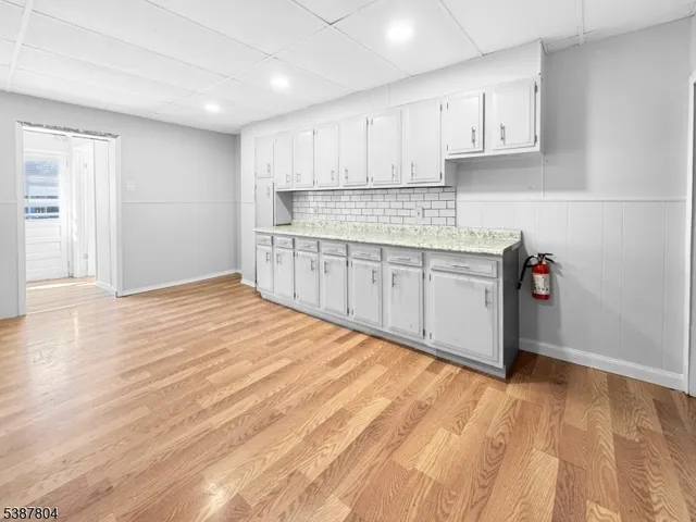 a kitchen with granite countertop white cabinets and white appliances