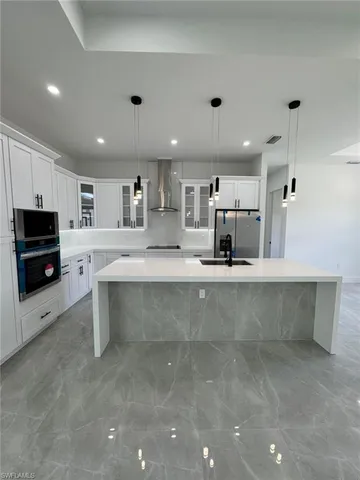 a large kitchen with stainless steel appliances a large counter top
