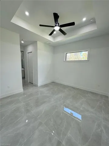 an empty room with ceiling fan and window