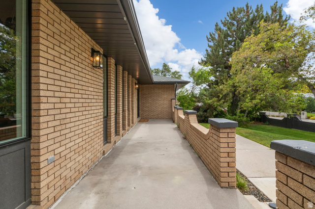 4150 Dover Lane Provo, UT 84604 - Photo 41 of 44 Brick exterior featuring a covered walkway, decorative wall sconces, and a concrete pathway