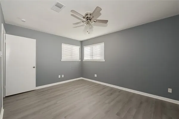 an empty room with a ceiling fan and window