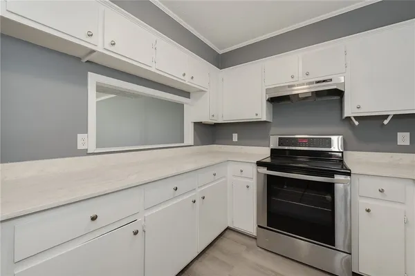 a kitchen with granite countertop white cabinets and stainless steel appliances