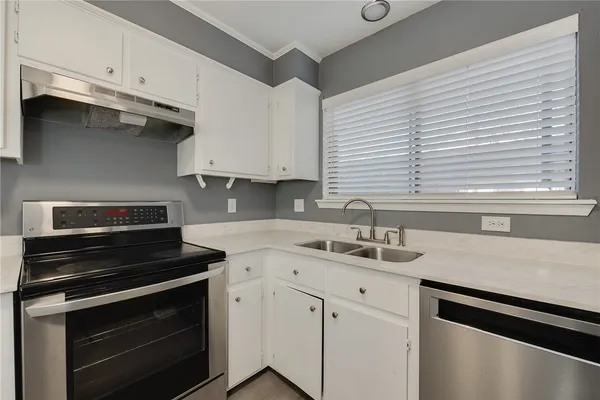 a kitchen with a sink stove and cabinets