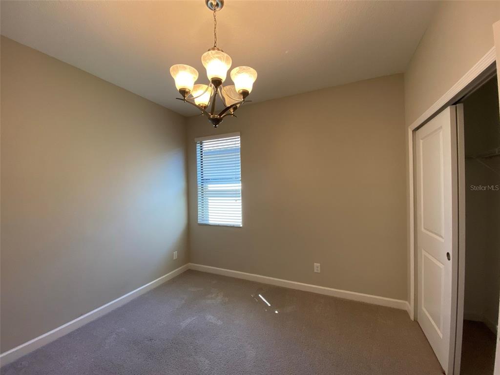 10049 Victory Gallop Loop Ruskin, FL 33573 - Photo 14 of 22 a view of an empty room with a chandelier