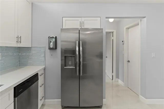 a metallic refrigerator freezer sitting in a kitchen