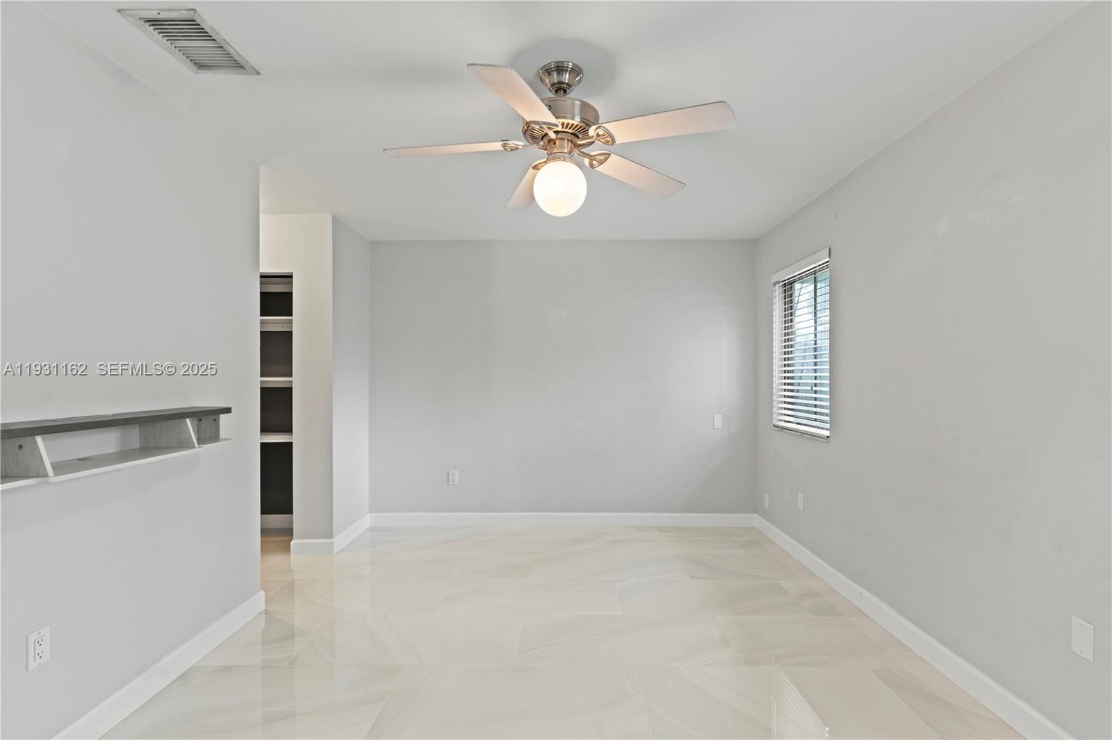 9301 Southwest 130th Street Miami, FL 33176 - Photo 17 of 32 an empty room with a ceiling fan and window