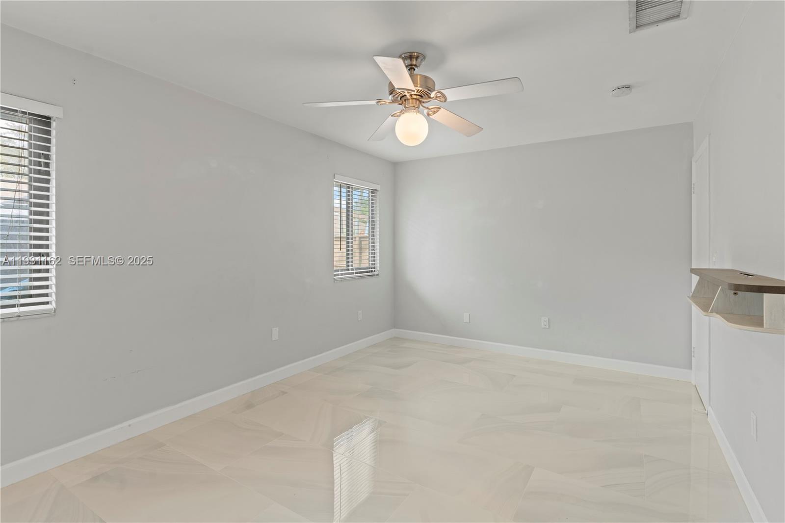 9301 Southwest 130th Street Miami, FL 33176 - Photo 20 of 32 a view of an empty room with a chandelier fan