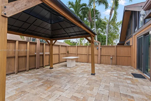 a view of a backyard of a house with table and chairs under an umbrella