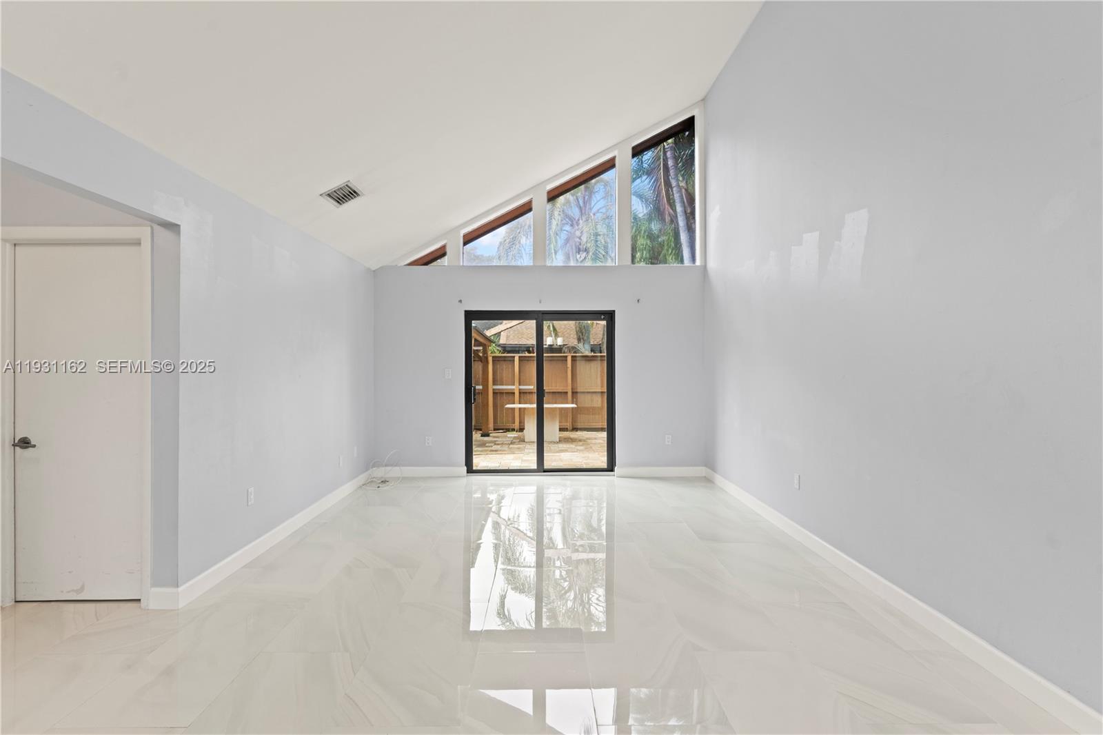 9301 Southwest 130th Street Miami, FL 33176 - Photo 4 of 32 an empty room with windows