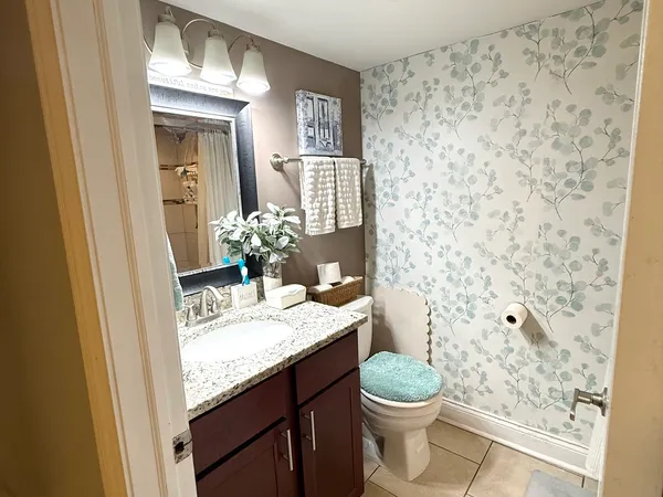 a bathroom with a granite countertop sink a toilet and a mirror