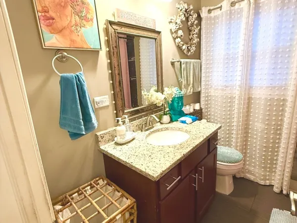 a bathroom with a granite countertop sink and a mirror
