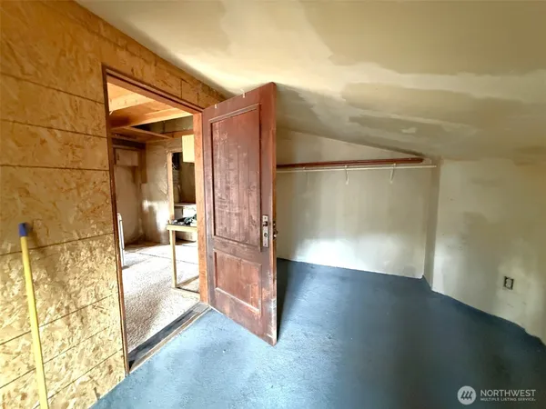 a view of a hallway with wooden floor and a bathroom
