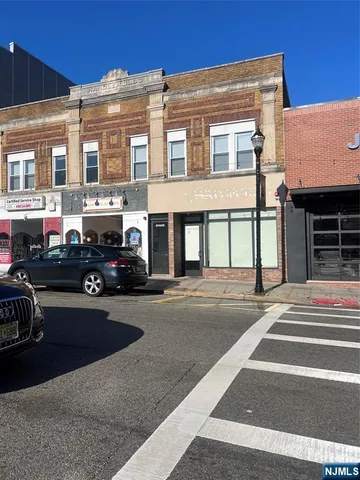 a front view of a building with cars parked