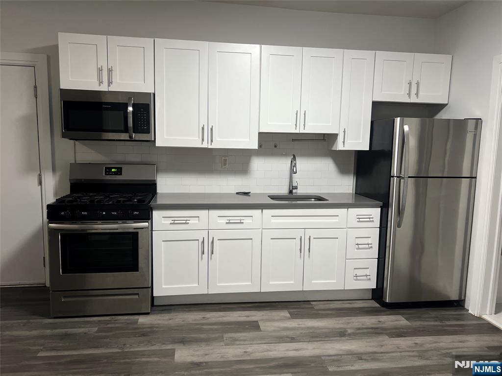 104 Park Avenue Rutherford, NJ 07070 - Photo 2 of 12 a kitchen with granite countertop white cabinets and stainless steel appliances