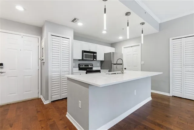 a kitchen with kitchen island a sink stainless steel appliances and cabinets