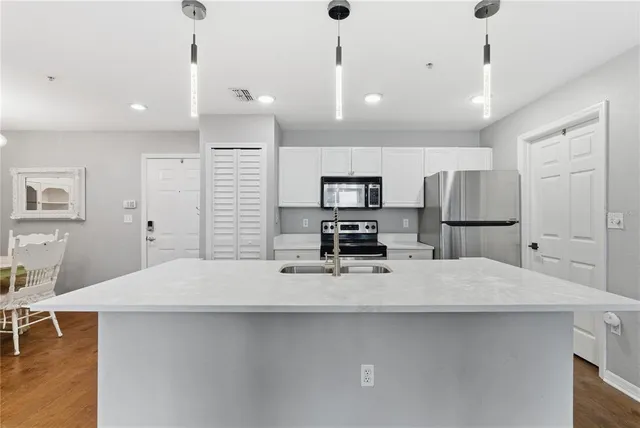 a kitchen with kitchen island a sink stainless steel appliances and counter space