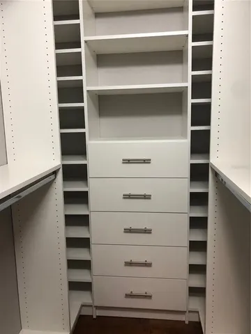 a view of walk in closet with empty racks