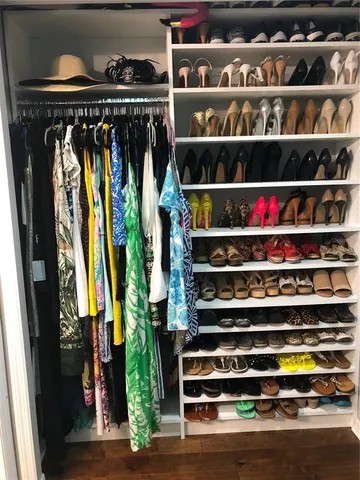 a view of walk in closet with clothes and shoes