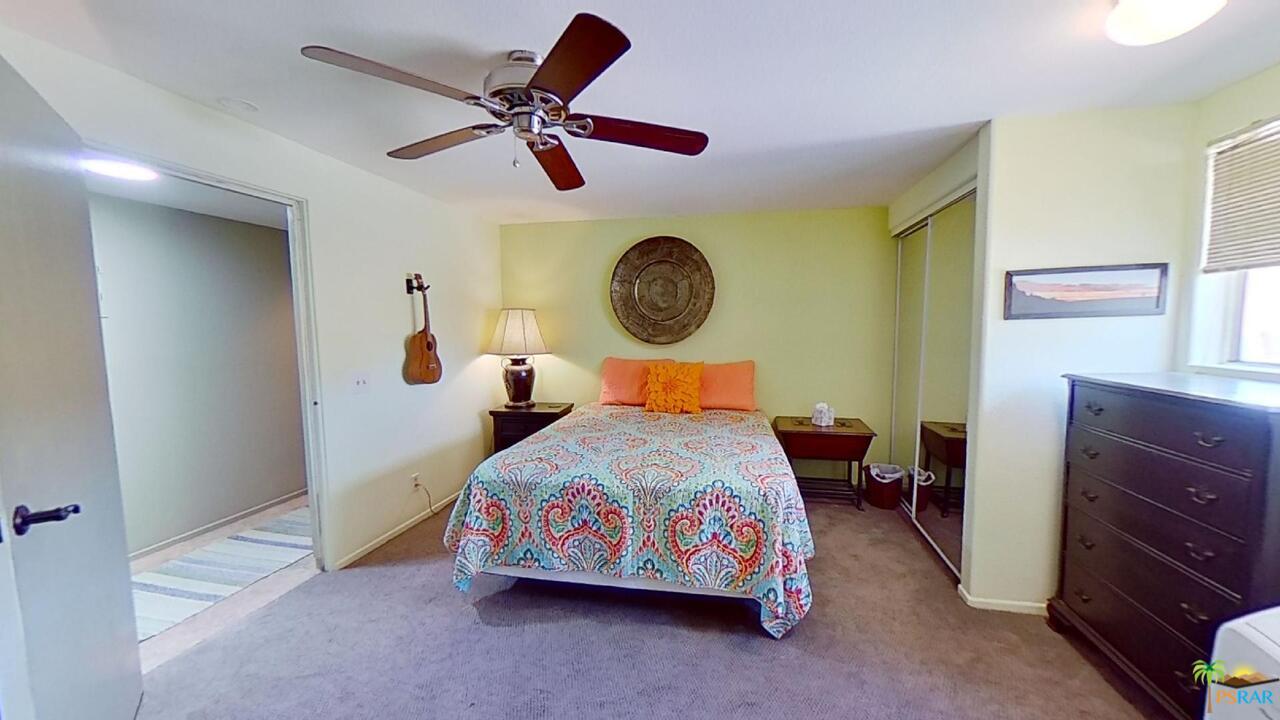 61612 Sagebrush Road North Palm Springs, CA 92258 - Photo 13 of 30 a bedroom with a bed and a chandelier