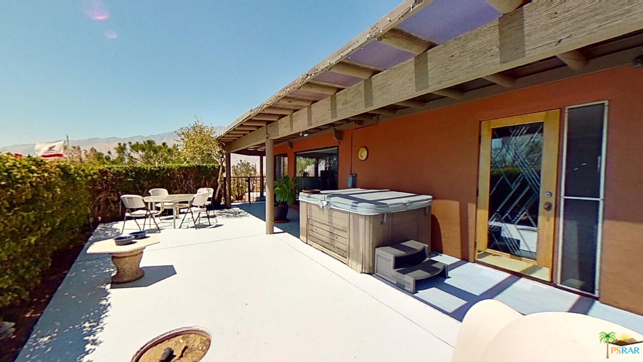 61612 Sagebrush Road North Palm Springs, CA 92258 - Photo 25 of 30 a view of a patio with table and chairs potted plants with floor to ceiling window