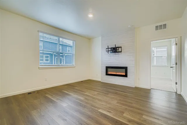 an empty room with windows and a fireplace