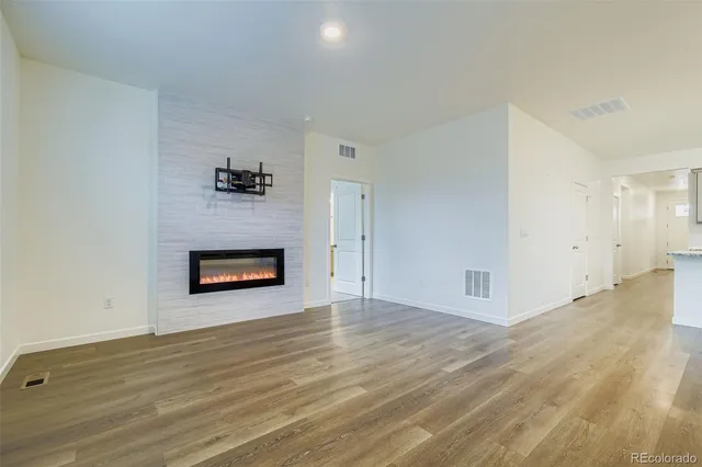 a view of an empty room with a fireplace and a window