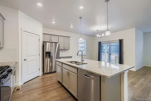 a kitchen with stainless steel appliances granite countertop a sink refrigerator and stove