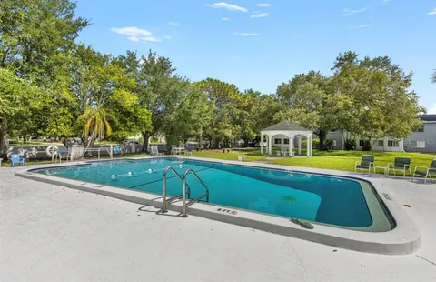 a view of a swimming pool with a yard and trees