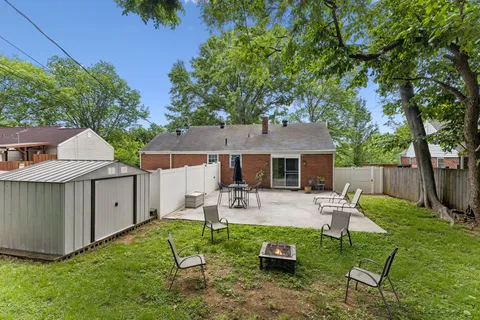 a view of house with backyard and outdoor seating