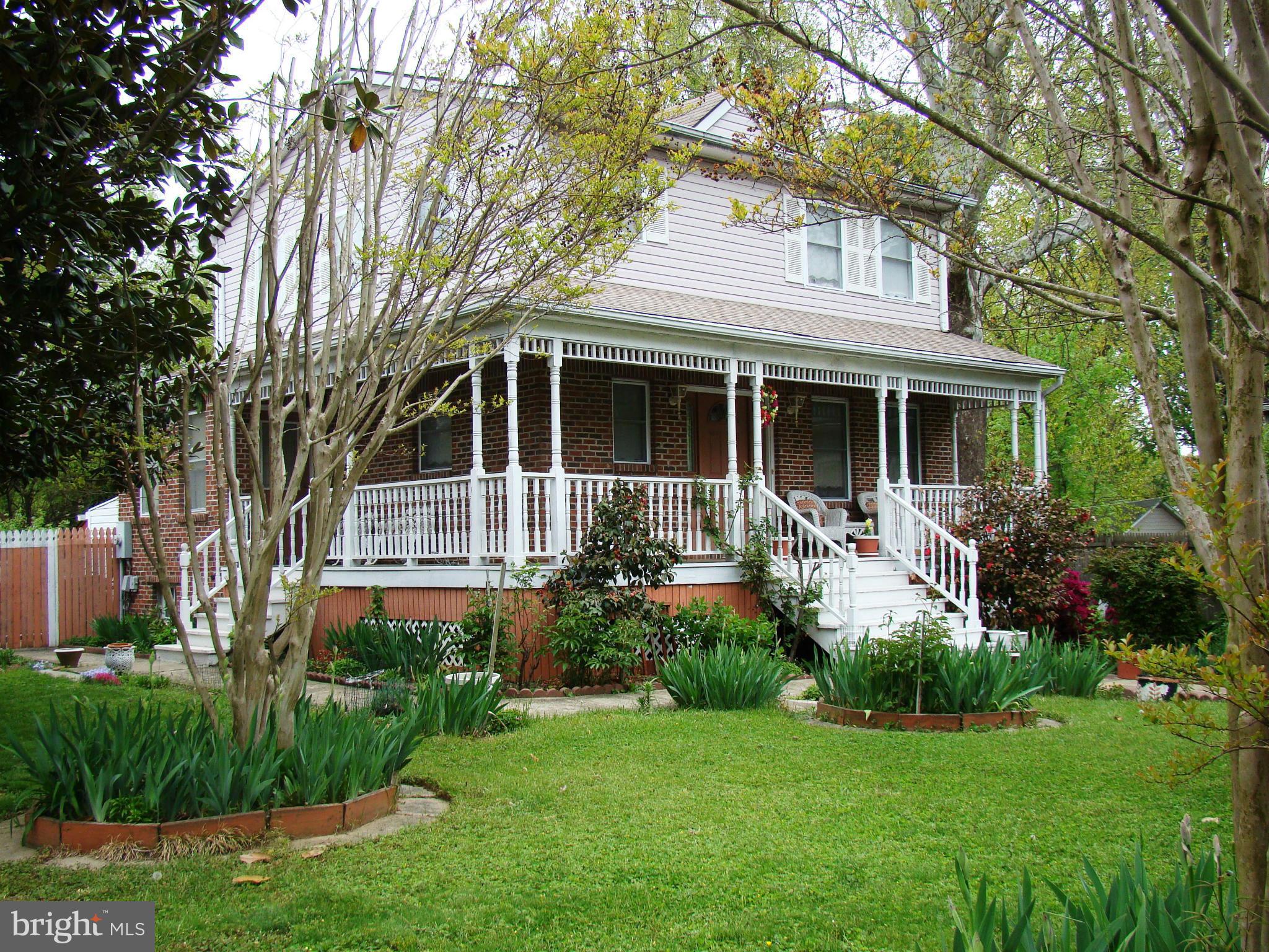 a front view of a house with a yard and potted plants