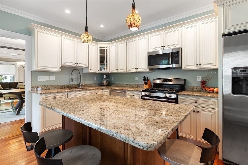 16 Orvis Road, Unit 1 Arlington, MA 02474 - Photo 14 of 31 a kitchen with kitchen island granite countertop a sink a counter top space appliances and cabinets