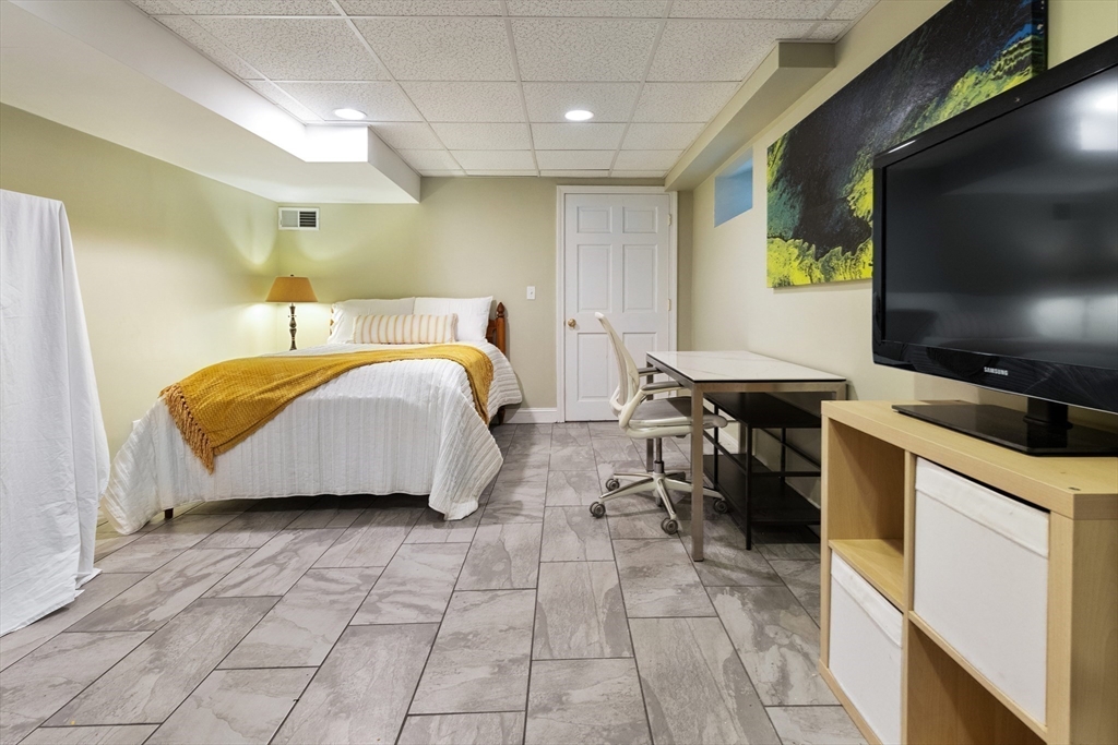 16 Orvis Road, Unit 1 Arlington, MA 02474 - Photo 23 of 31 a spacious bedroom with a bed and a flat screen tv