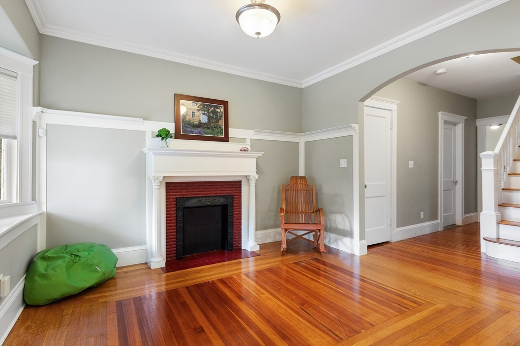 16 Orvis Road, Unit 1 Arlington, MA 02474 - Photo 7 of 31 a living room with a fireplace and a wooden floor