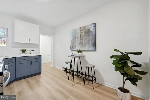 a kitchen with stainless steel appliances granite countertop a sink a stove a dining table with chair and wooden floor