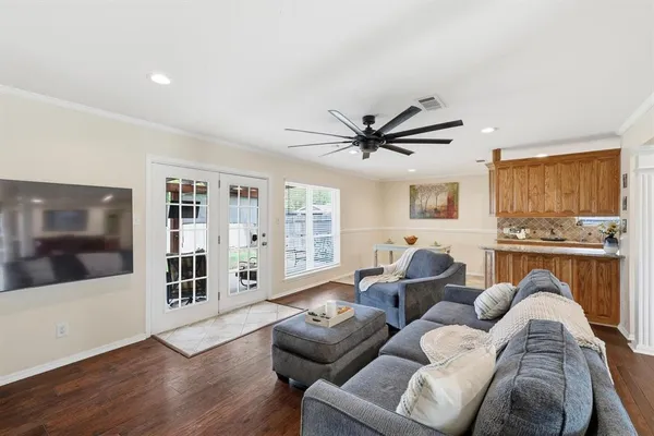 a living room with furniture floor to ceiling window and wooden floor
