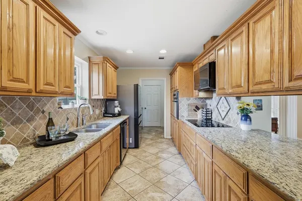 a kitchen with granite countertop a sink a counter top space appliances and cabinets