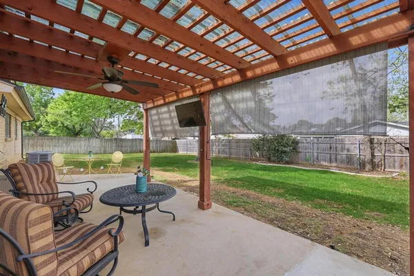 a view of a patio with a table chairs and a backyard
