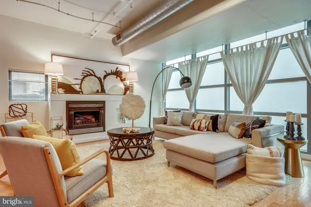 a living room with furniture a fireplace and a large window