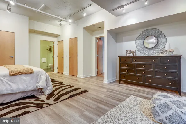 a bedroom with a bed and wooden floor