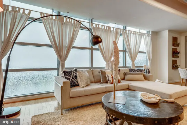 a living room with furniture and a floor to ceiling window