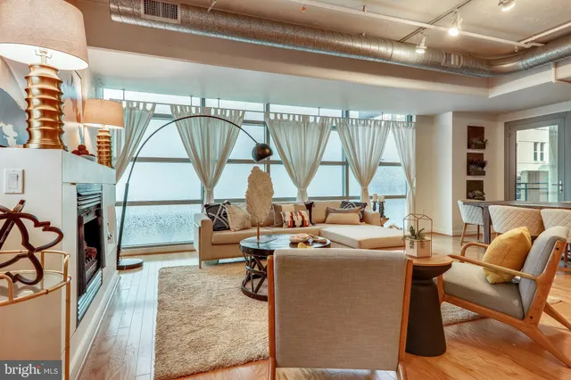 a living room with furniture a large window and a chandelier