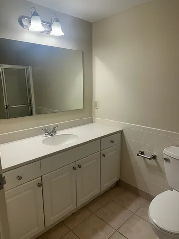 a bathroom with a toilet sink and mirror