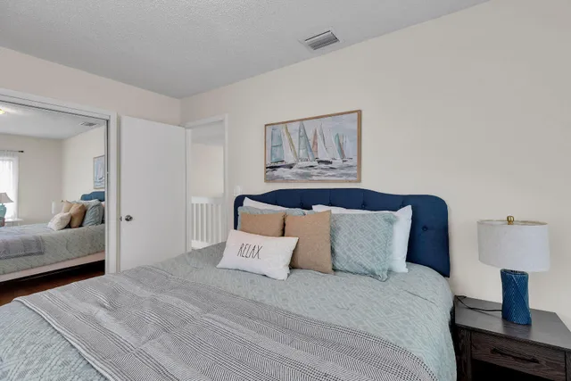a bedroom with a bed and wooden floor