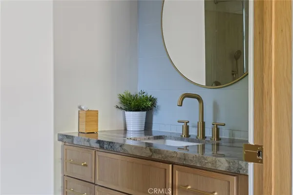 a bathroom with a granite countertop sink and a mirror