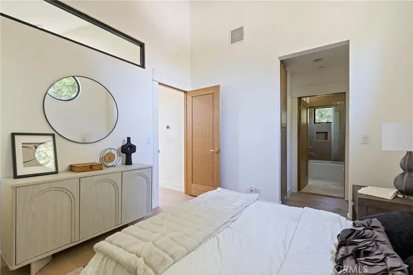 a bedroom with bed and a mirror