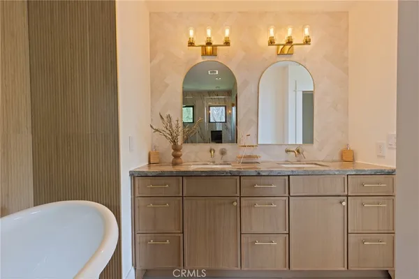 a bathroom with a granite countertop sink a large mirror and vanity