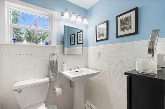 a bathroom with a toilet sink and mirror
