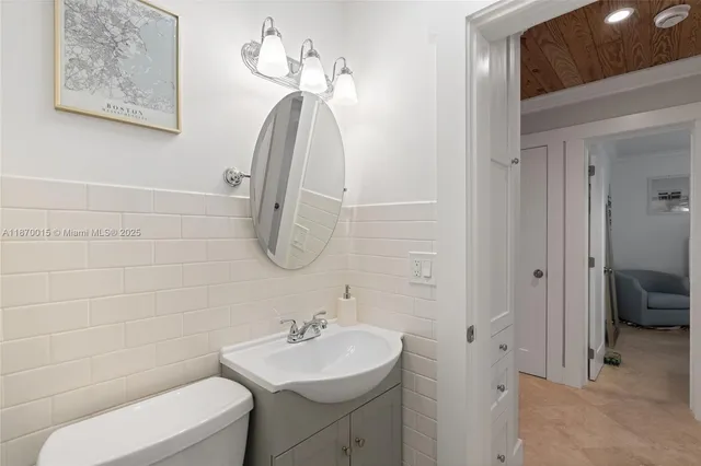 a bathroom with a toilet a sink and mirror