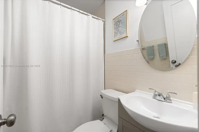 a bathroom with a sink and mirror with toilet