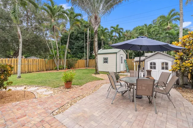 a patio with a table and chairs under an umbrella
